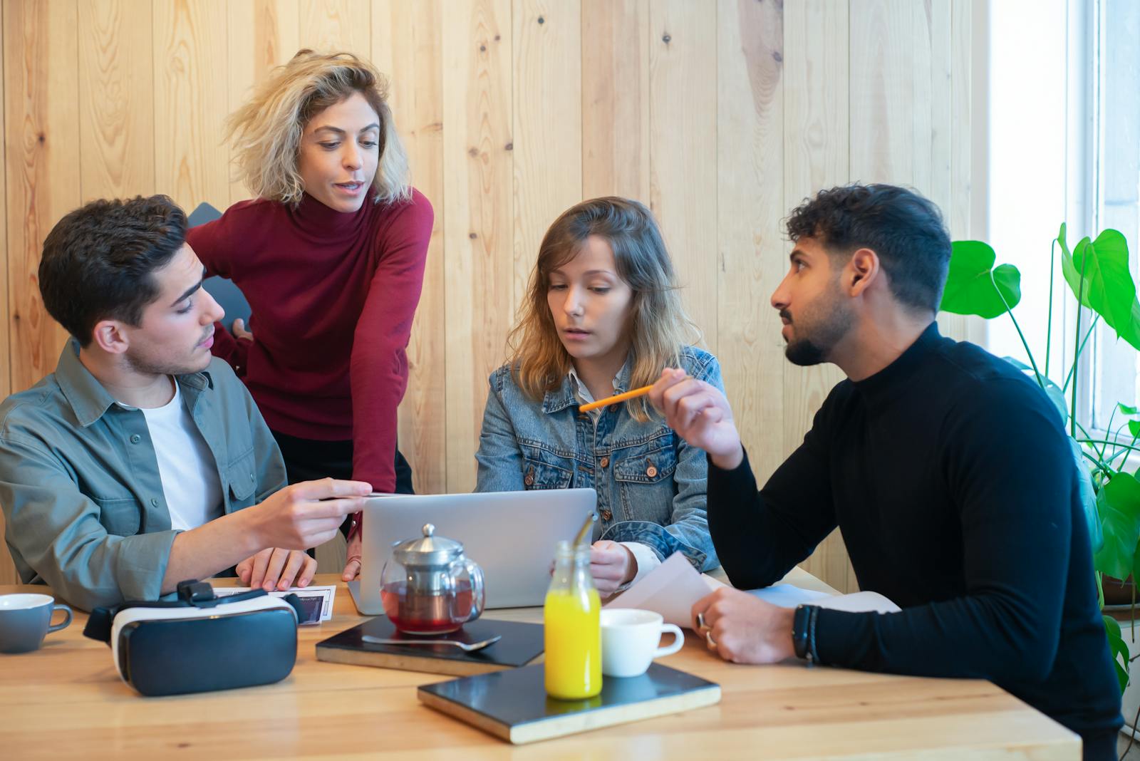 Profissionais colaborando em reunião com laptop em mesa